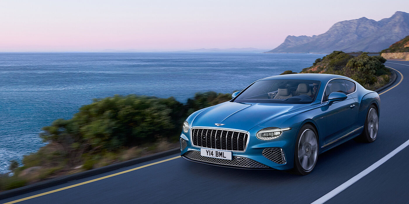 Bentley Santiago New Bentley Continental GT Azure coupe in Light Windsor blue paint with 22 inch Azure wheels and chrome grill, driving dynamically by the sea